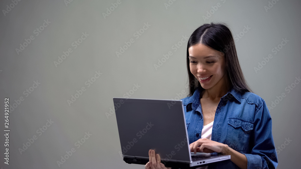 Smiling asian woman chatting on laptop, communicating with friends, new app Smiling asian woman chatting on laptop, communicating with friends, new app