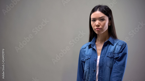 Εκτύπωση καμβά Asian lady suspiciously looking at camera, isolated on grey background, mistrust