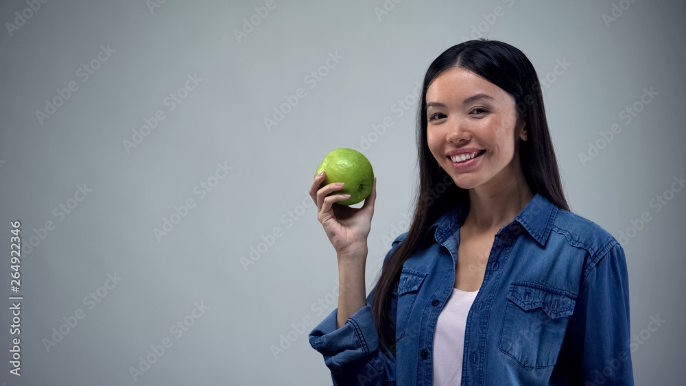 Attractive woman posing with juicy apple on grey background healthcare, template Attractive woman posing with juicy apple on grey background healthcare, template