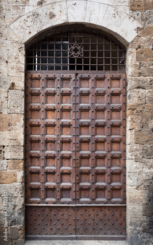 Ancient wooden portal with stone arch of an Italian medieval fortress.