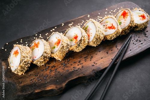 Tempura maki. Japanese sushi tempura roll on wooden platter. Japanese traditional fusion food style, restaurant menu