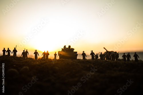 War Concept. Military silhouettes fighting scene on war fog sky background  World War Soldiers Silhouettes Below Cloudy Skyline at sunset. Attack scene. Armored vehicles.