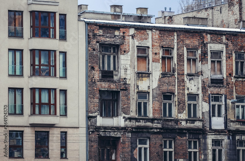Modern residential building next to ruined tenement in Warsaw city, Poland