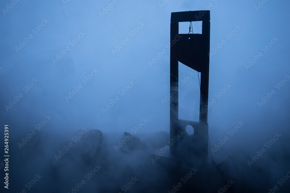 Horror view of Guillotine. Close-up of a guillotine on a dark foggy background. - obrazy, fototapety, plakaty 
