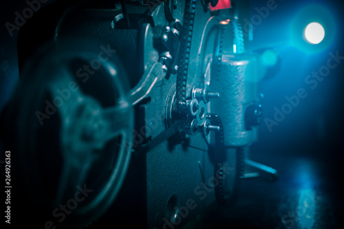 Old vintage movie projector on a dark background with fog and light. Concept of film-making.