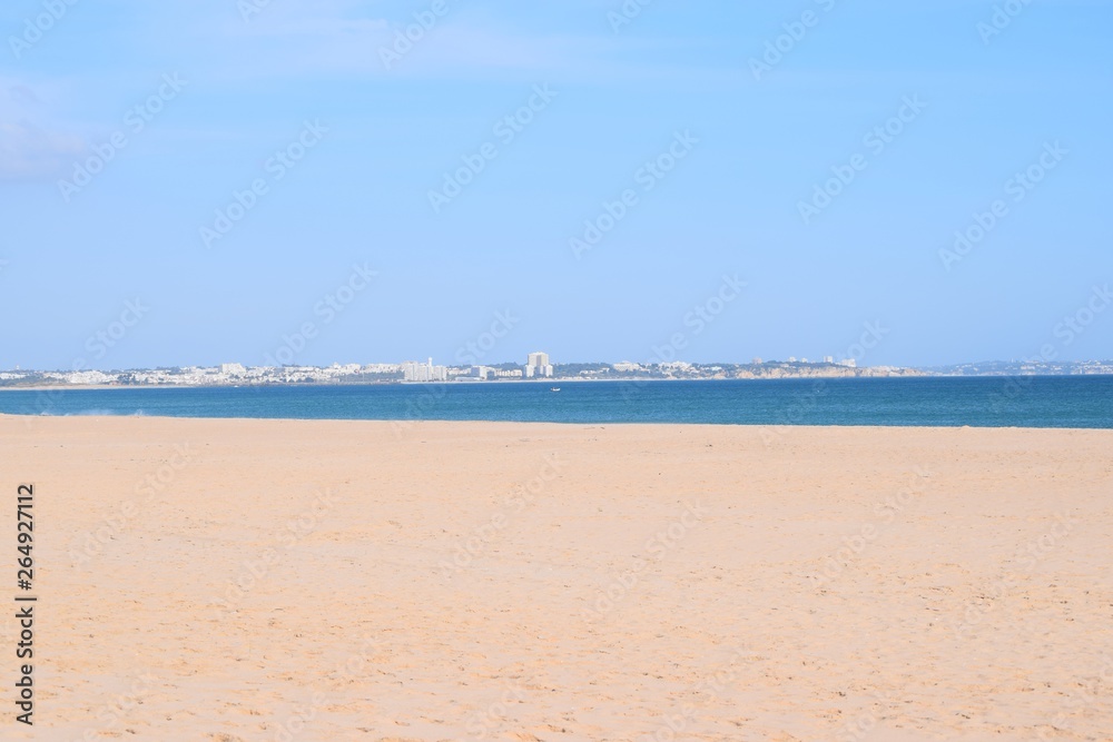 The big beach Meia Praia in Lagos, Algarve, Portugal with view to the city of Alvor