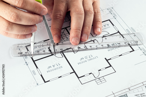 Male hands, Orange helmet, pencil, architectural construction drawings, tape measure. The architect designs the building. The concept of architecture, construction, engineering, design. Copy space.