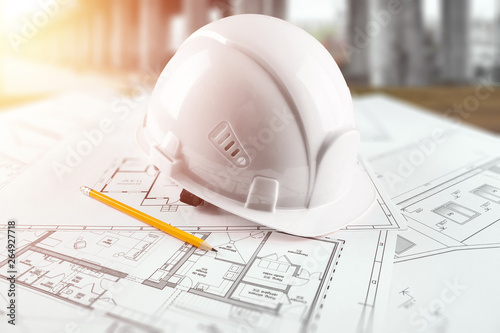 Orange helmet, pencil, architectural construction drawings, tape measure. The concept of architecture, construction, engineering, design. Copy space.