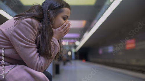 Foto Desperate lady suffering anxiety attack at subway station, feeling helpless