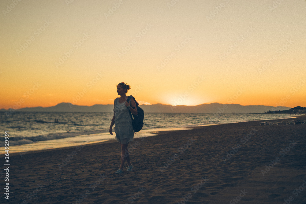 girl walking on the beach at sunset