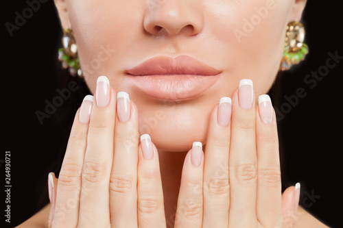 Perfect female hands with manicured nails and lips. French manicure and beige lipstick makeup
