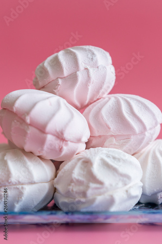 Pink and white marshmallows on a pink background