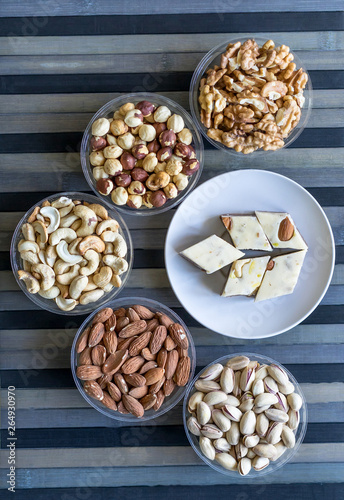 Oriental dessert halva with pistachio, almond, cashew nuts, peanut, walnut  on a  plate. Image. Healthy food. closeup of sweets from Iran popular  Turkish Delight. Isolated on background
