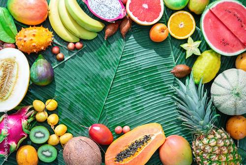 Fototapeta Naklejka Na Ścianę i Meble -  Assortment of tropical fruits on leaves of palm trees