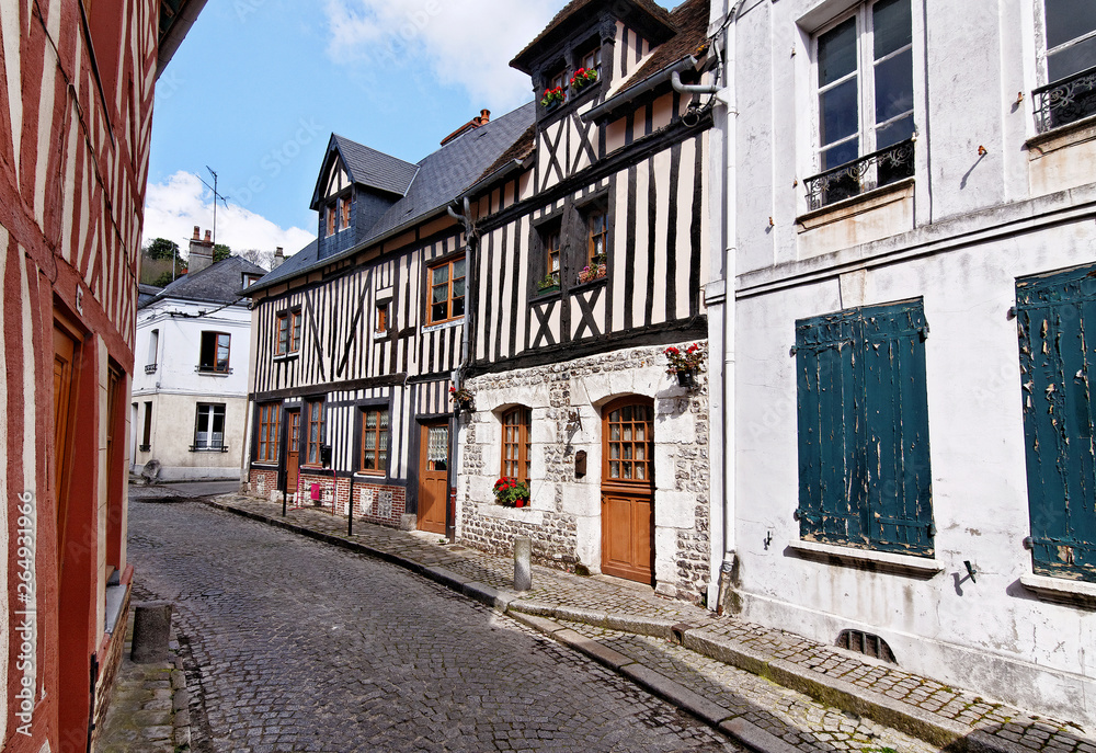 Old cobblestone street with buildings at Honfleur, Normandy, France. Typical French architecture. Calm street with white houses.