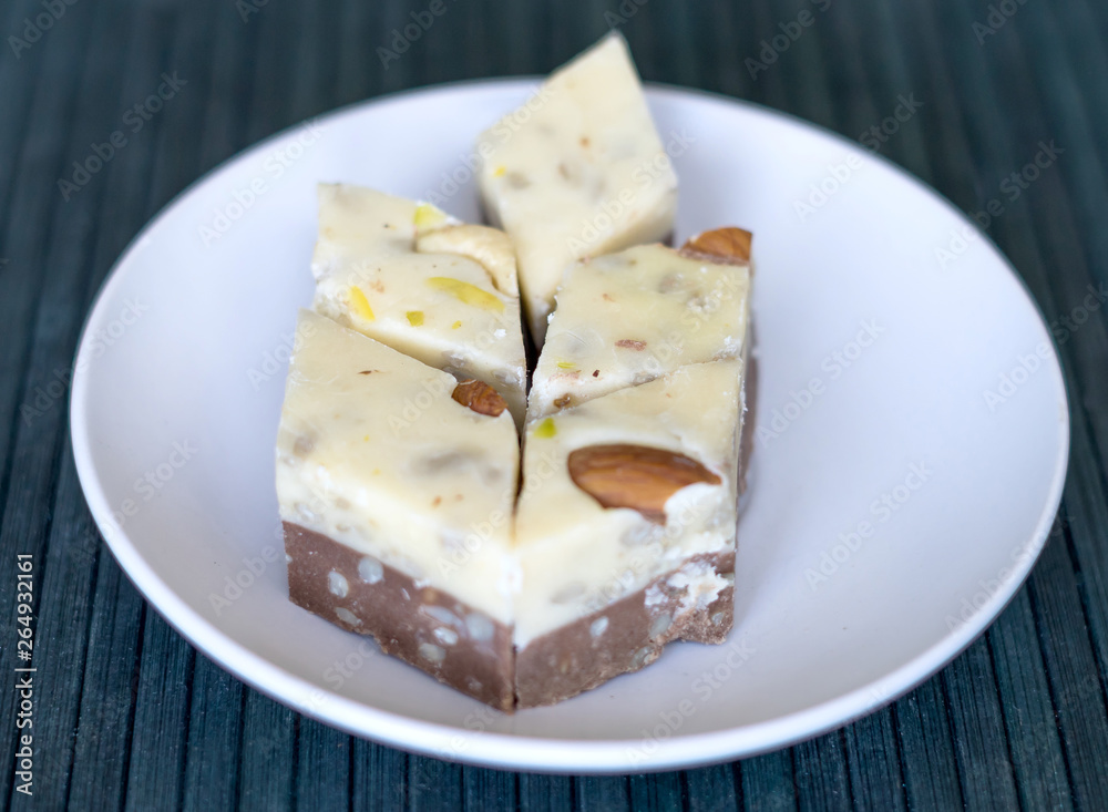 Oriental dessert halva with pistachio, almond, cashew nuts, peanut, walnut  on a  plate. Image. sweets from Iran Turkish Delight. Isolated on background