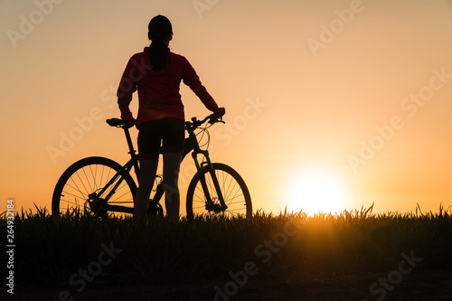 woman at sunset from sunset Bike bike. woman practicing sports.