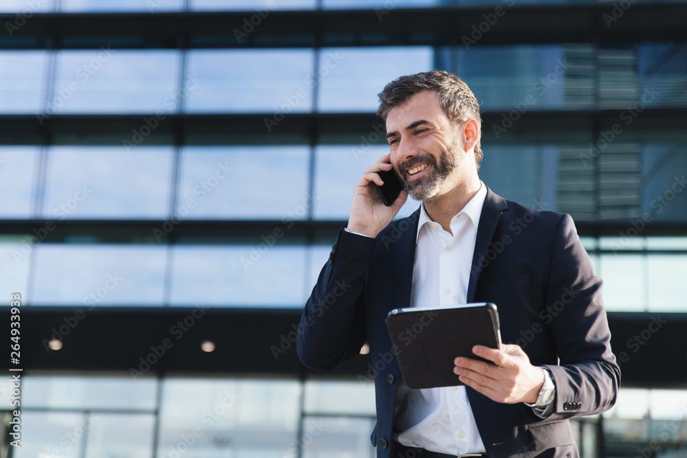 Hombre de negocios hablando por teléfono sonriente - obrazy, fototapety, plakaty 