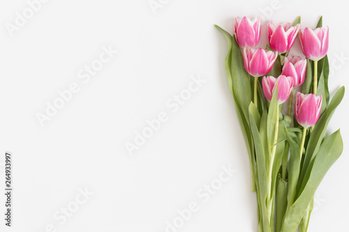 Fototapeta Naklejka Na Ścianę i Meble -  Top view of bouquet of pink tulips on a white table. Flat lay with blank copy space.
