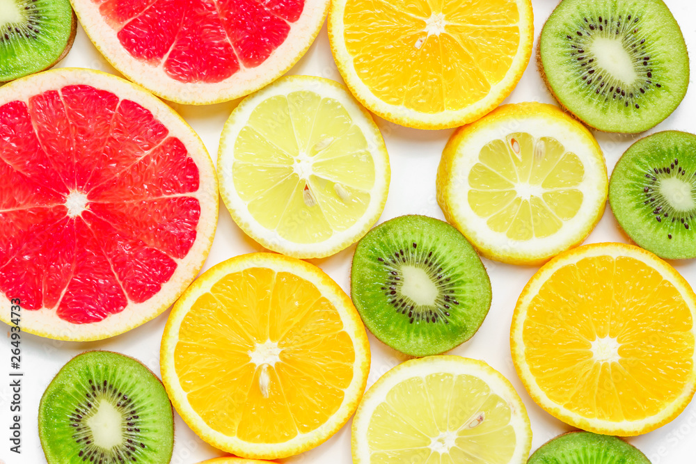 Fototapeta premium citrus slices - kiwi, oranges and grapefruits on white background. Fruits backdrop