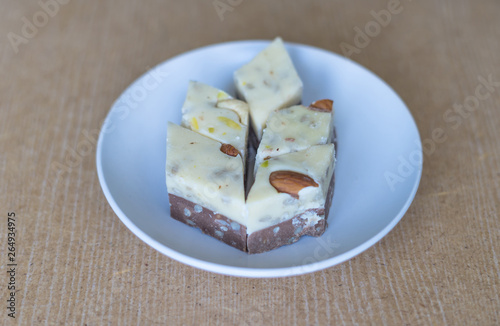 Traditional Turkish Delight. Oriental dessert halva on a plate. Isolated on background. Eastern delicacy sweets. Healthy food. Nuts mix assortment. image close up nuts, pistachios, almond, cashew nut
