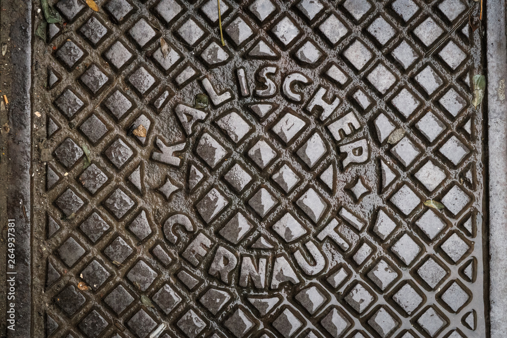 Close up of hatch in Chernivtsi, Ukraine. Metal rusty manhole cover. Translation: Close up of hatch in Chernivtsi, Ukraine. Metal rusty manhole cover. Translation: