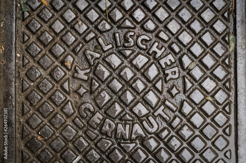 Close up of hatch in Chernivtsi, Ukraine. Metal rusty manhole cover. Translation: 