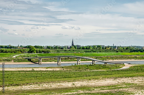View across the floodplains of the river Waal near Nijmegen, The Netherlands with the Zaligebrug pedestrian bridge across the new river Channel and the church tower of Lent in the distance