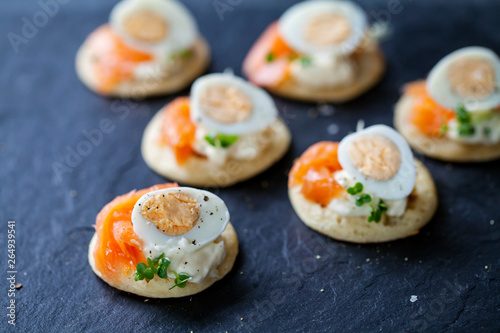Party food, blinis with salmon, quail egg and caviar
