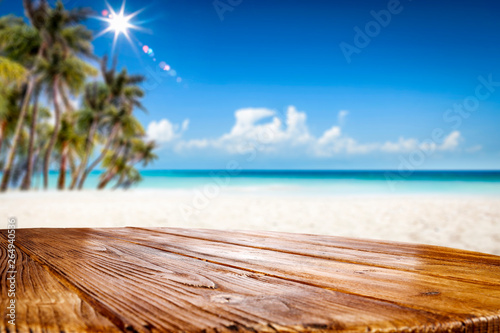 Summer table background of free space for your decoration and landscape of beach with palms. 