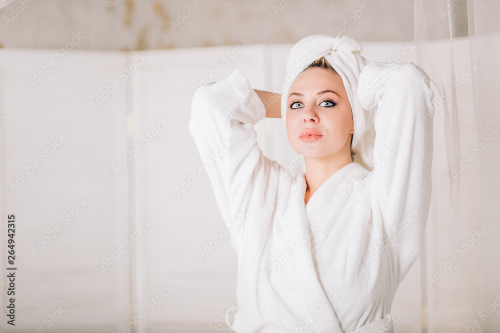 Young smiling woman in bathrobe with towel on head Young smiling woman in bathrobe with towel on head