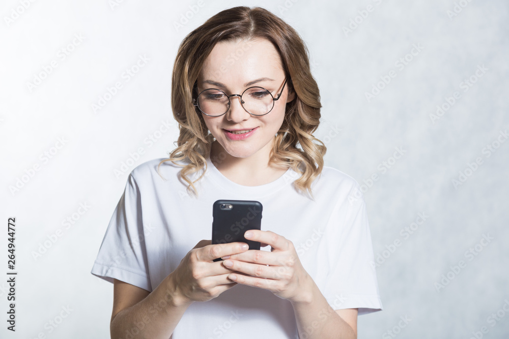 Perplexed and worried, a beautiful young woman is holding a smartphone, stares with surprised expression. Perplexed and worried, a beautiful young woman is holding a smartphone, stares with surprised expression.