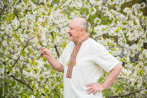 Senior man in embroidered shirt at blossom garden