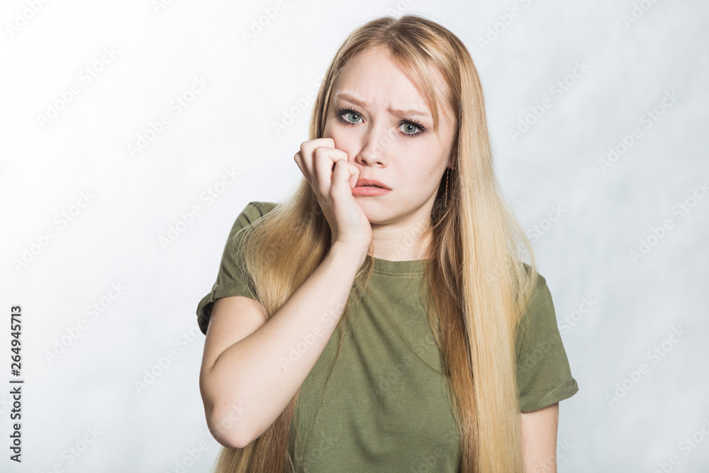 Young woman feels anxious, bites finger nails in confusion. Young woman feels anxious, bites finger nails in confusion.