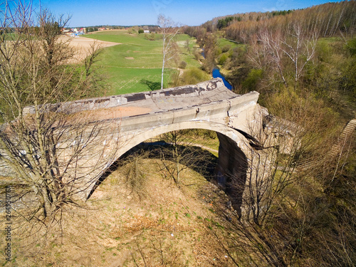 Destroyed railway bridge over Sapina river, Kruklanki town in the background, Poland (former Kruglanken, East Prussia) photo