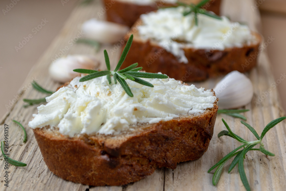 Sliced bread with light cheese on a wooden board. Sliced bread with light cheese on a wooden board.