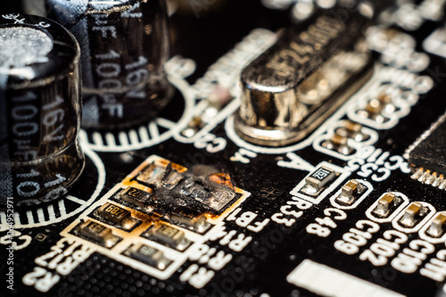 Damaged microelectronics, macro photography. Burned out resistor.