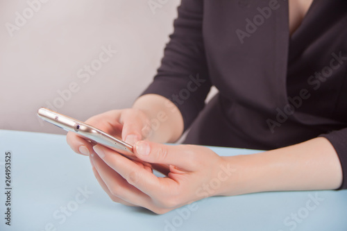 Young beautiful business woman holding phone in the office.