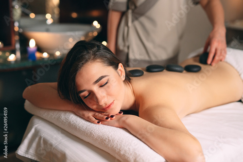 Spa, massage. Young dark-haired beautiful girl doing massage.