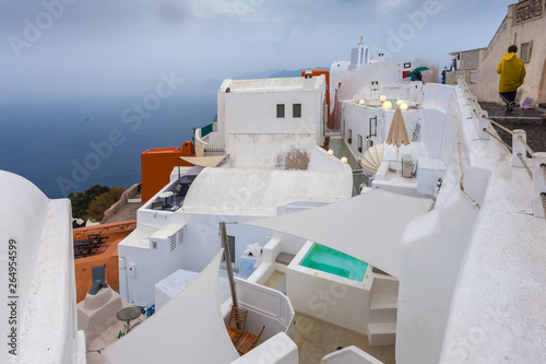 View of white houses of Oia and caldera on a rare rainy day