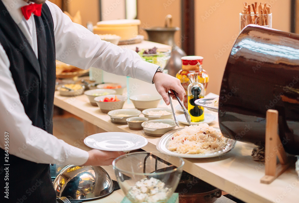 Sauerkraut. Breakfast at the hotel or restaurant. The waiter lays the sauerkraut in the dish. Sauerkraut. Breakfast at the hotel or restaurant. The waiter lays the sauerkraut in the dish.