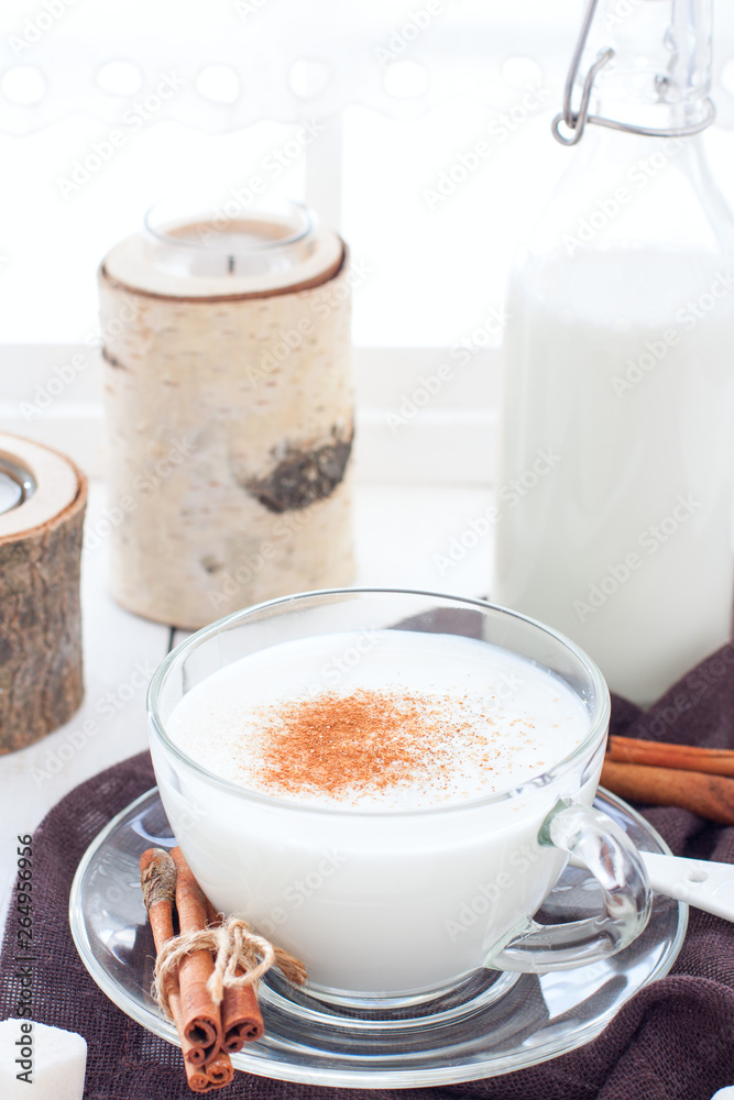 Homemade kefir in a glass cup with cinnamon and sugar, selective focus Homemade kefir in a glass cup with cinnamon and sugar, selective focus