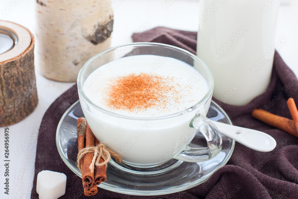 Homemade kefir in a glass cup with cinnamon and sugar, horizontal Homemade kefir in a glass cup with cinnamon and sugar, horizontal