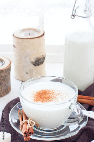 Homemade kefir in a glass cup with cinnamon and sugar, selective focus