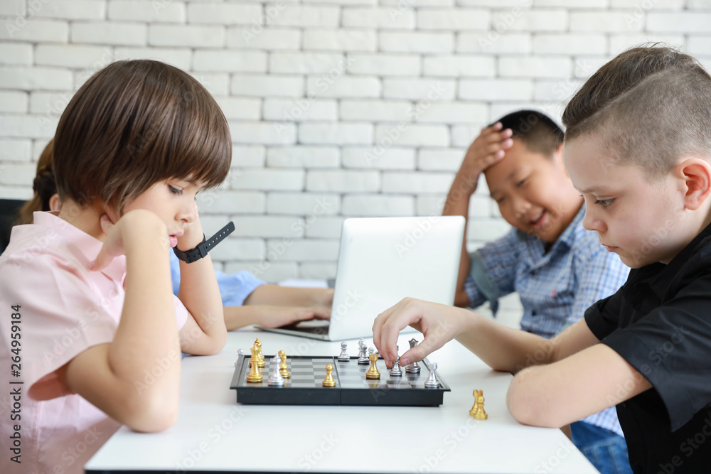 cute and smart kids playing chess in class cute and smart kids playing chess in class