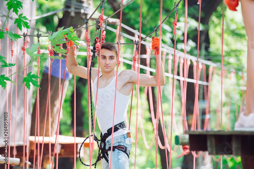 Man spend their leisure time in a ropes course. Man engaged in rope park.