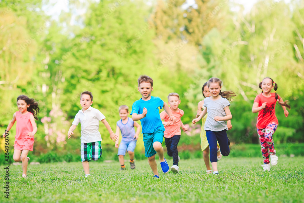 Many different kids, boys and girls running in the park on sunny summer day in casual clothes Many different kids, boys and girls running in the park on sunny summer day in casual clothes