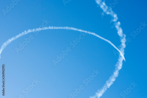Airplane trails on blue sky with copy space. © JYPIX