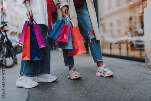 Young women with shopping bags standing on the street