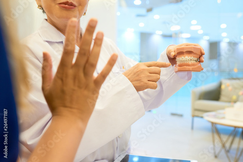 Orthodontist showing jaw to patient